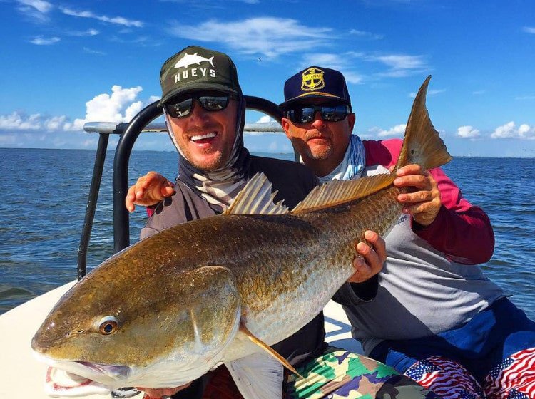 Jason Ducker on his charter boat with a huge redfish