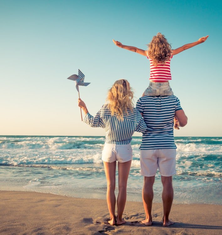 Family of 3 with girl on fathers shoulders on St. George Island Beach