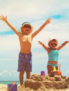 2 kids enjoying building a sand castle on St. George Island Florida