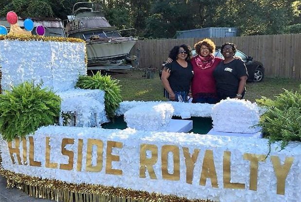 Three ladies standing behind parade float for Apalachicola's H'Cola Festival
