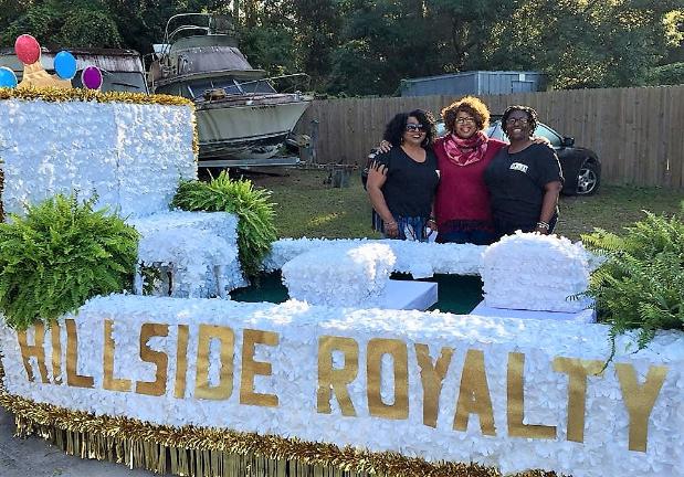 Three ladies standing behind parade float for Apalachicola's H'Cola Festival