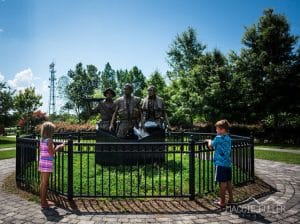 Kids looking at the memorial statue in Apalachicola