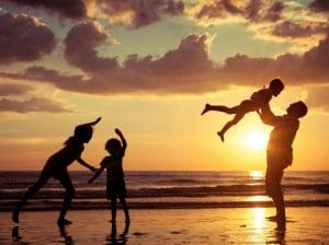 Father and children playing on the beach