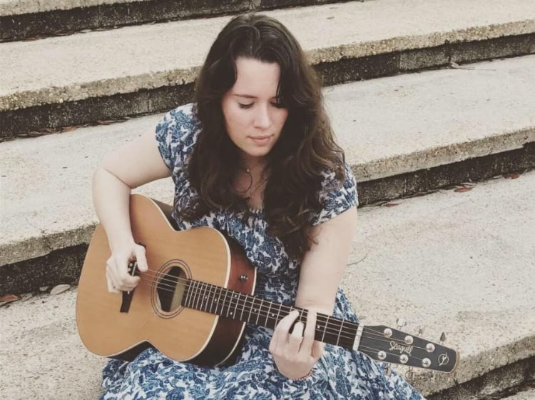 Woman playing guitar on steps