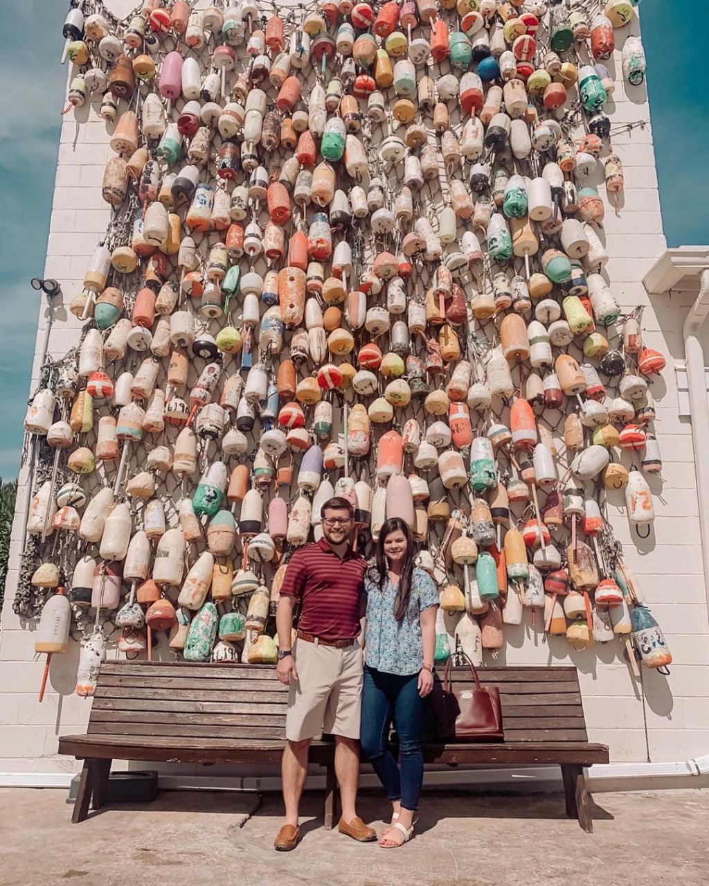 Couple standing in front of Buoys in Apalachicola FL