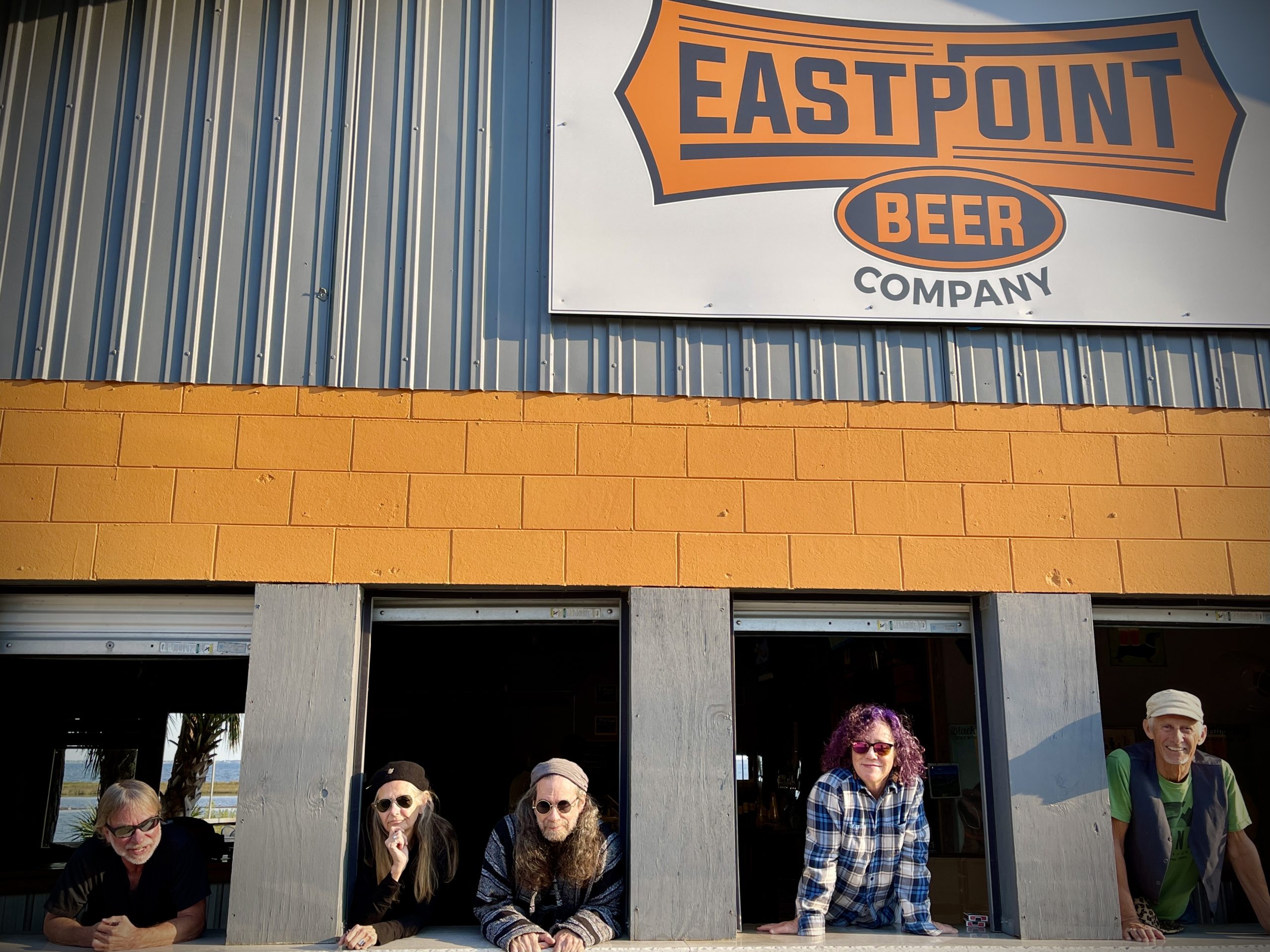 the band Hot Mess hanging out of the windows of a Eastpoint Beer Company