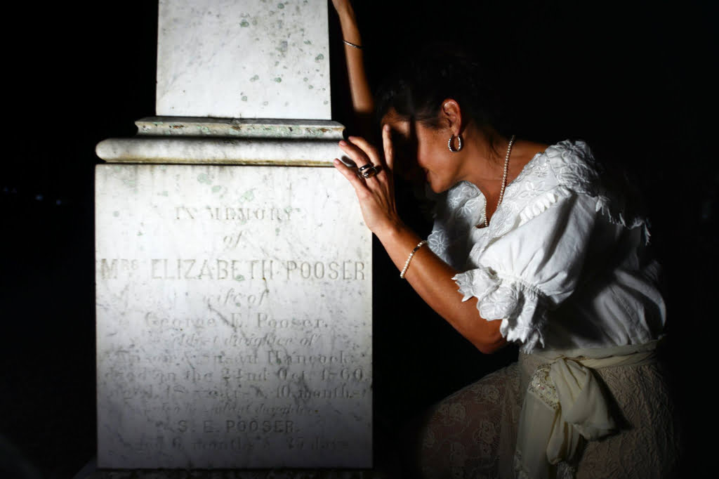 Photo of ghostly woman crying on a gravestone at the Chestnut Street Cemetery in Apalachicola, FL.