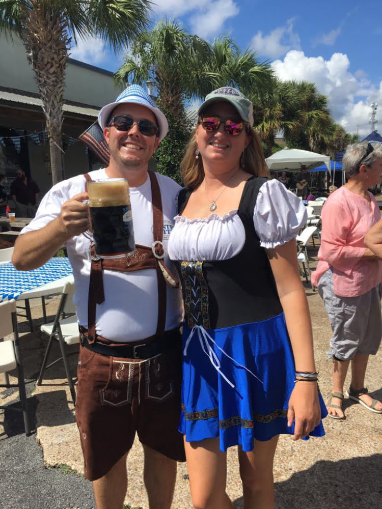 Photo of couple dressed in German clothing with beer at Oyster City Brewing Company's Oktoberfest in Apalachicola, FL.