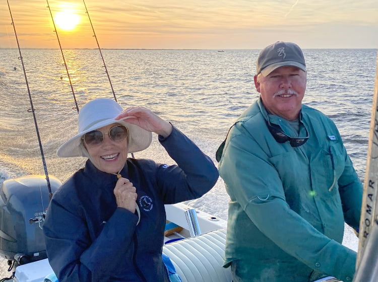 Couple on boat with fishing poles in background