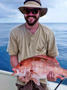 Person holding red snapper fish