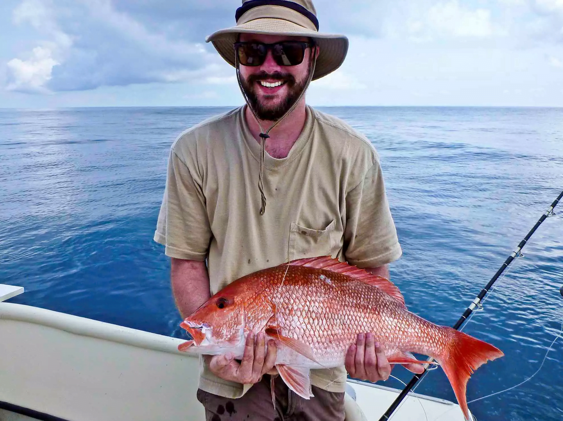 Person holding red snapper fish